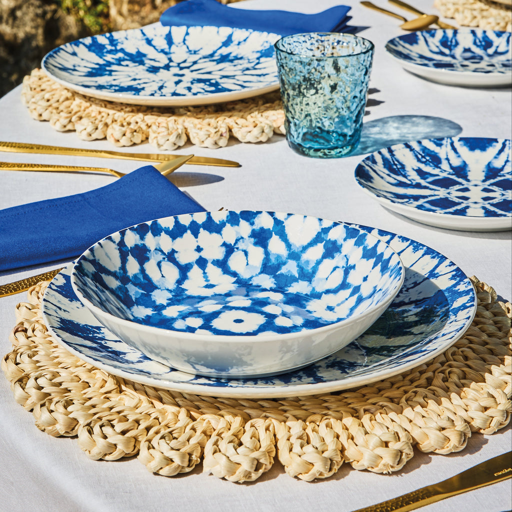 kompozycja z wykorzystaniem niebieskich talerzy mirage ustawionych na okrągłym stole i plecionek podkładce