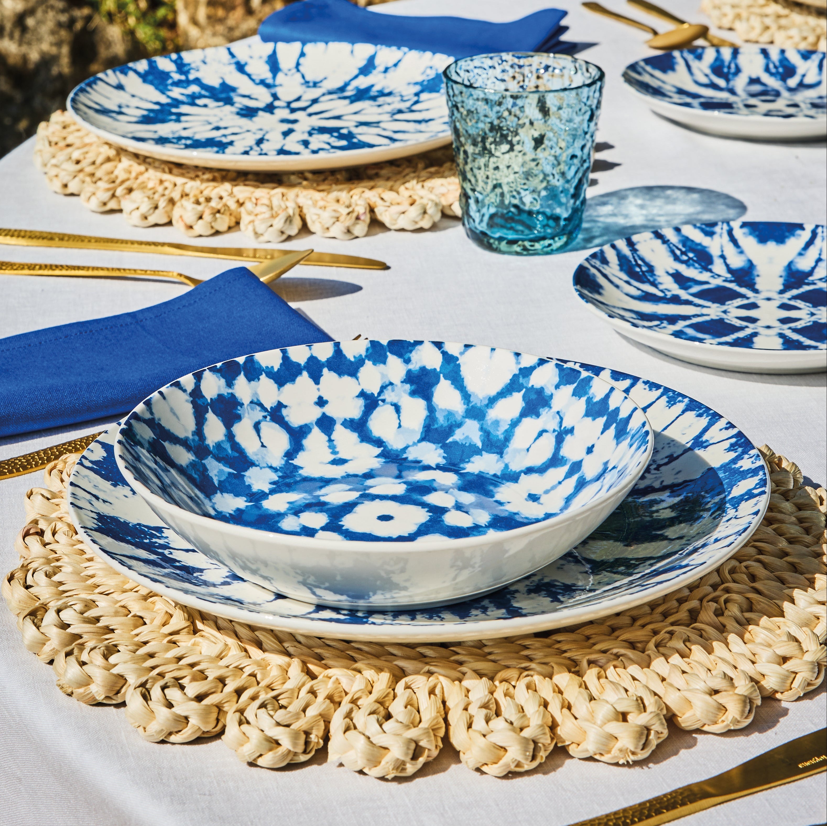 kompozycja z wykorzystaniem niebieskich talerzy mirage ustawionych na okrągłym stole i plecionek podkładce